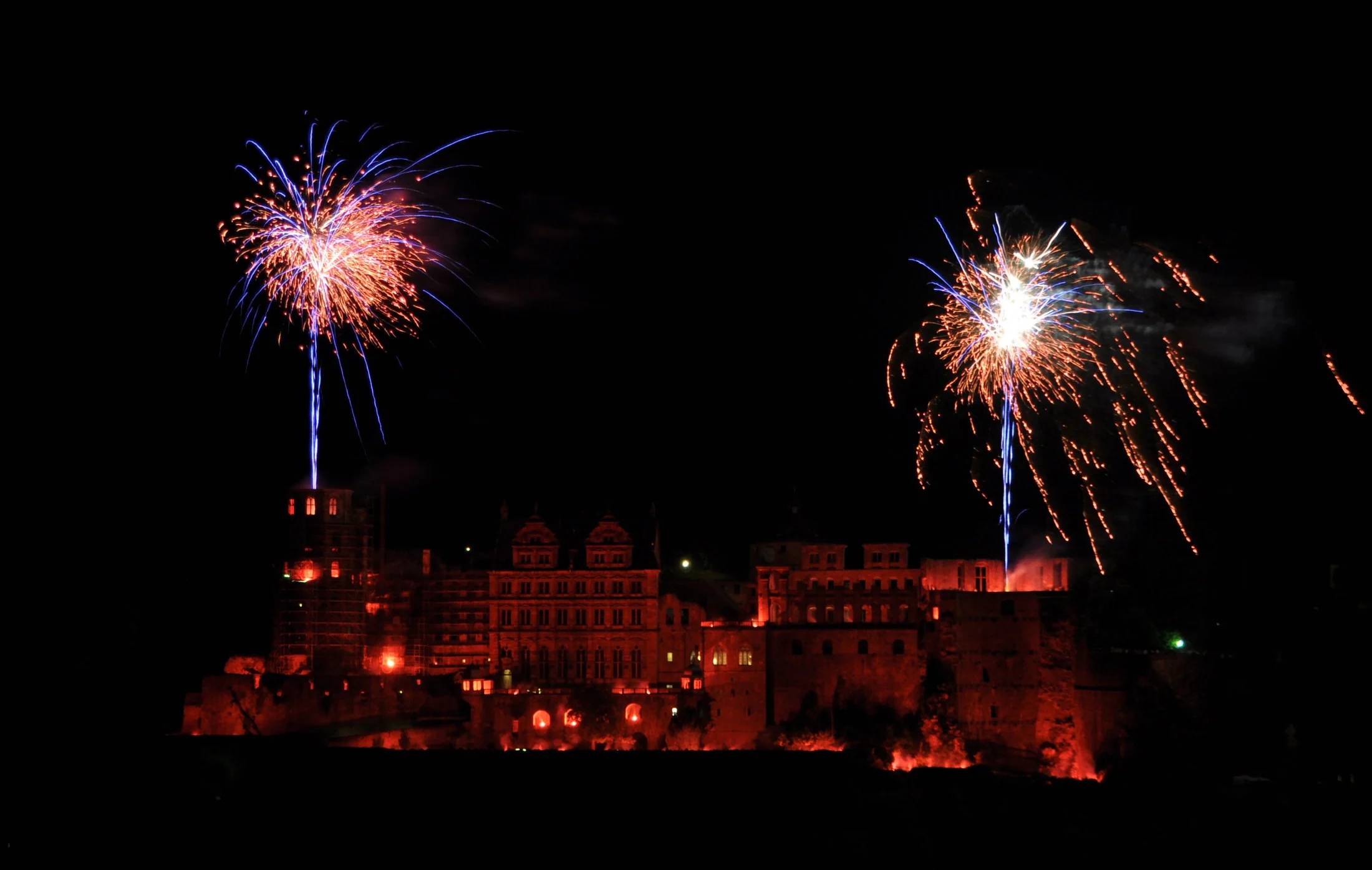 Heidelberg Castle glowing red with fireworks during the castle illumination